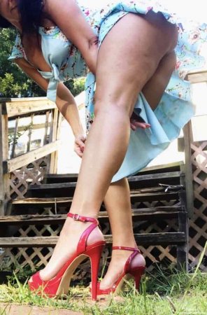 Зрелая красотка с большой попой в цветочном платье без трусиков позирует на природе эротические фото